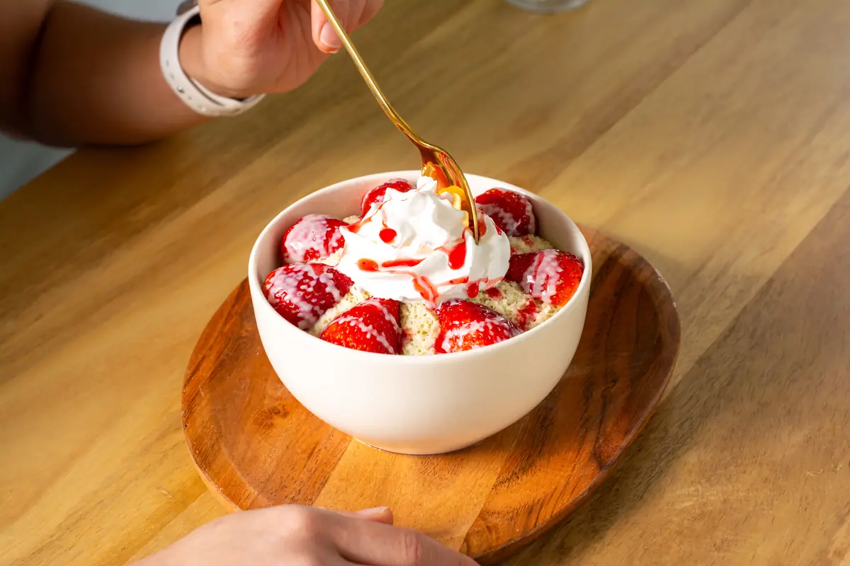 Alguien disfruta un snowty de fresa en la mesa